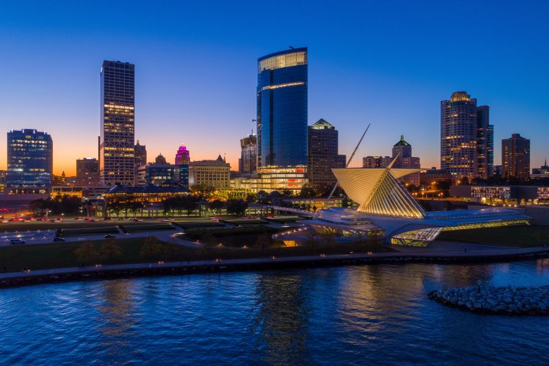 Milwaukee skyline at twilight showing the Milwaukee Art Museum and Lake Michigan shoreline.